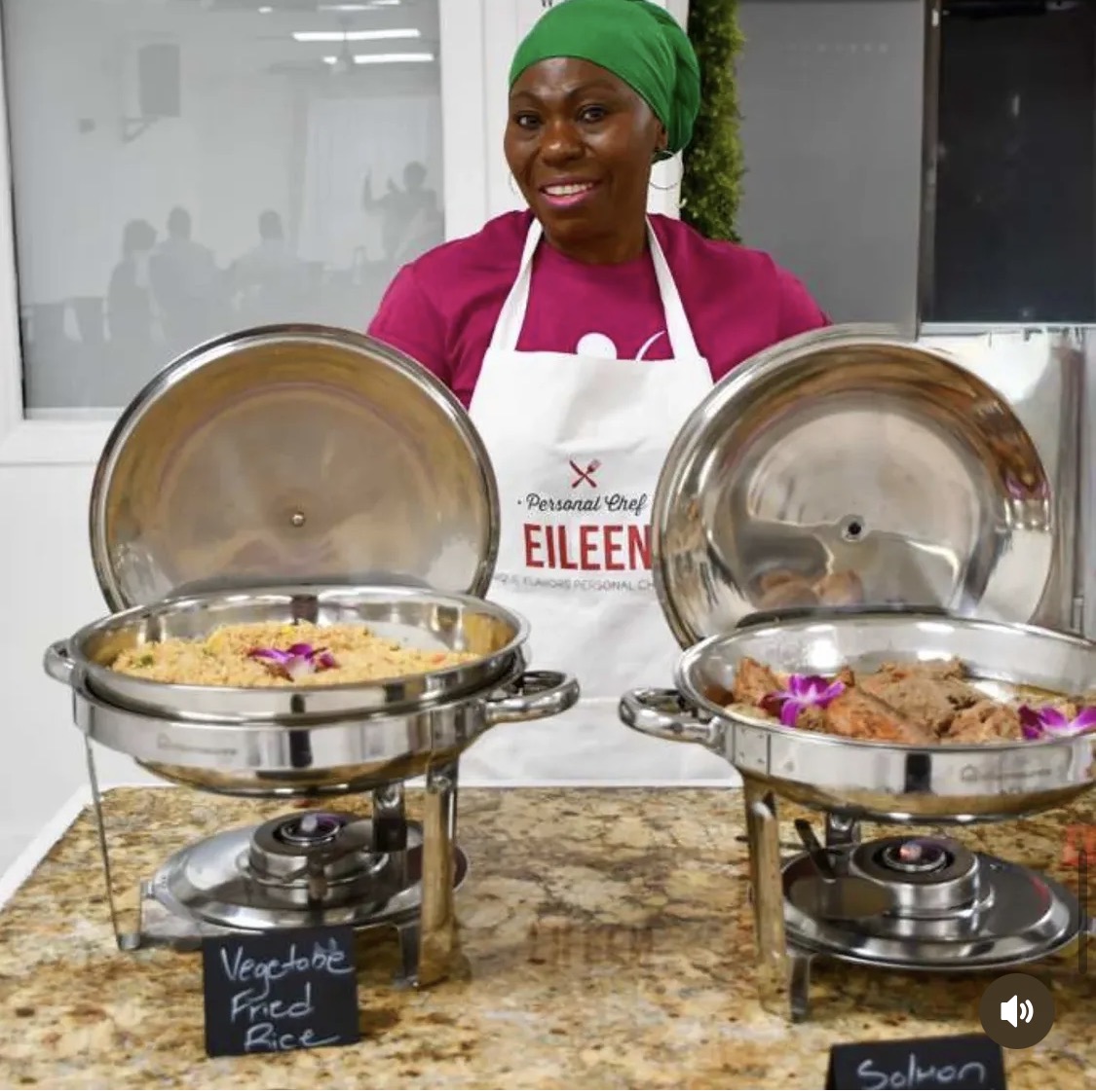 Chef Eileen serving vegetable fried rice and salmon from gold chafing dishes